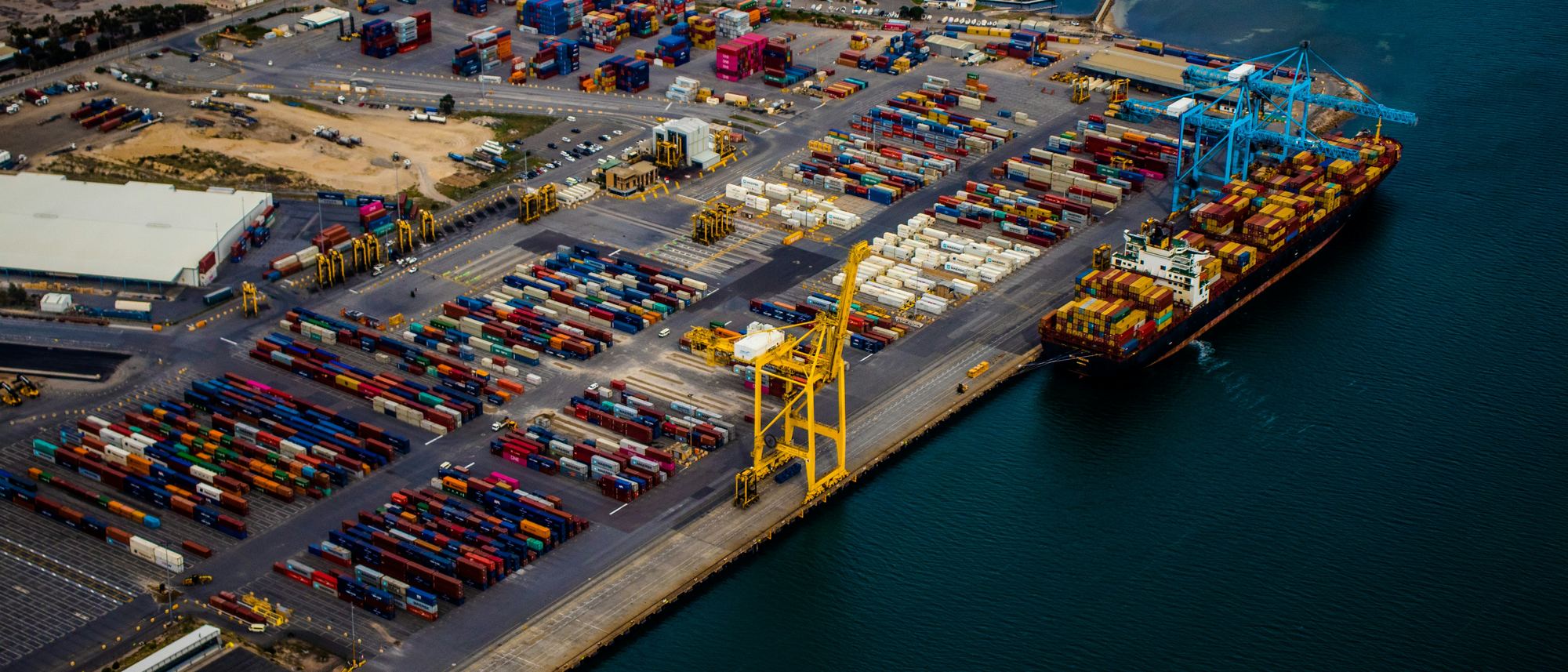 A container terminal from the air, with a ship alongside and cranes working